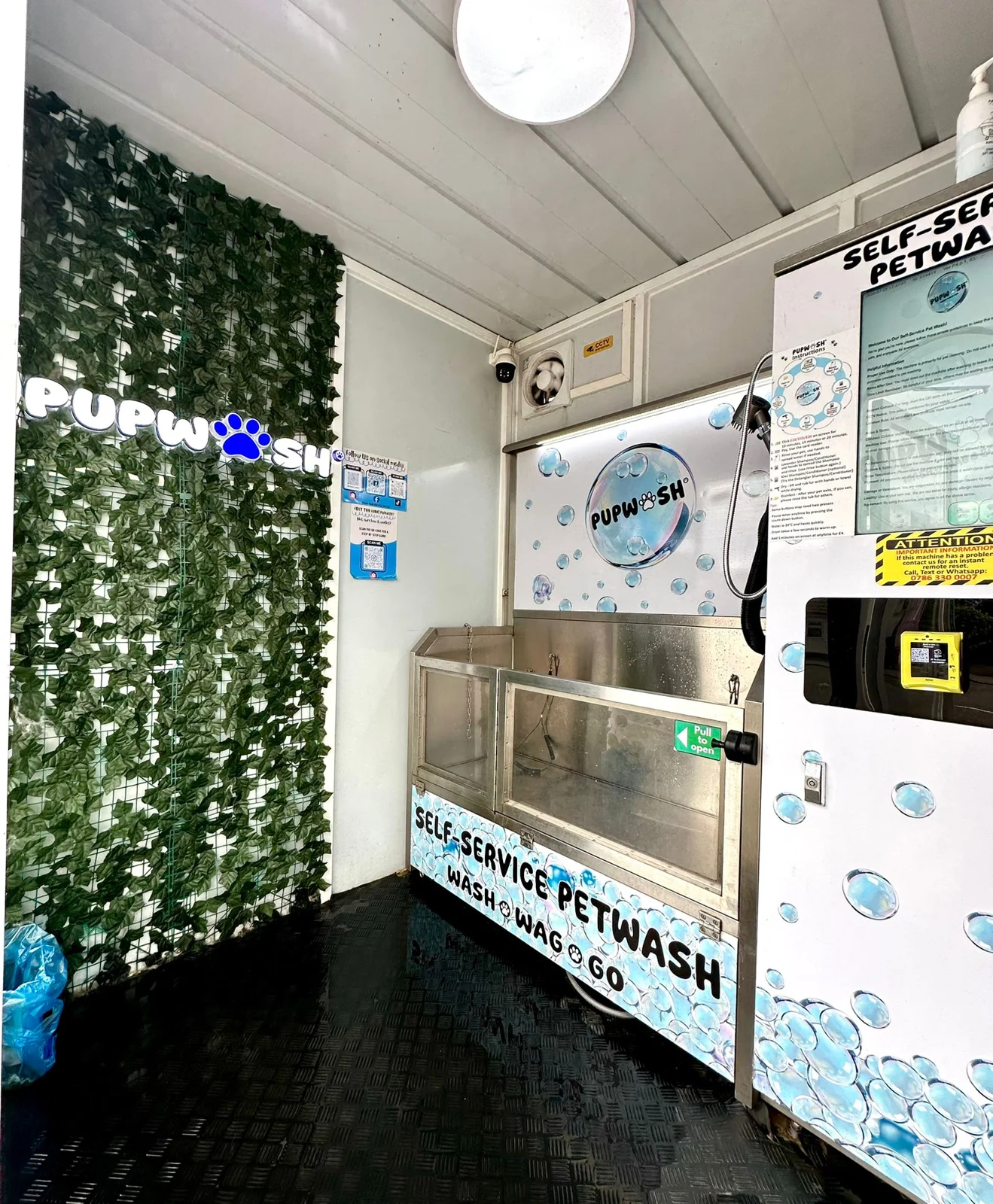 Inside a Pupwash kiosk showing the stainless steel tub and wash controls